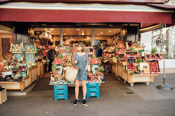 Young woman standing outside fruit and vegetable store