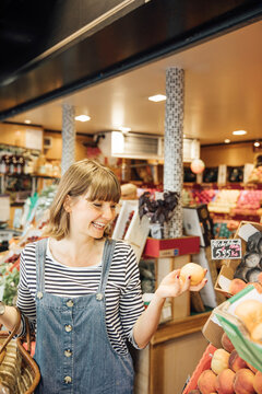 Smiling young woman in fruit and vegetable store