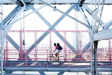  Man cycling on bridge © Image Source