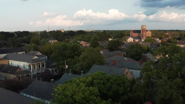 Drone flies backwards above Algiers Point, New Orleans revealing courthouse at sunset