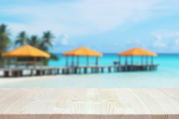 an empty wooden table on a blurry tropical background.