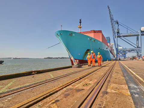 Dock workers and cargo ship at Port of Felixstowe, England