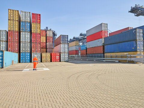 Solitary dock worker survey of container stack at port