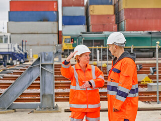 Dock workers talking by railroad tracks