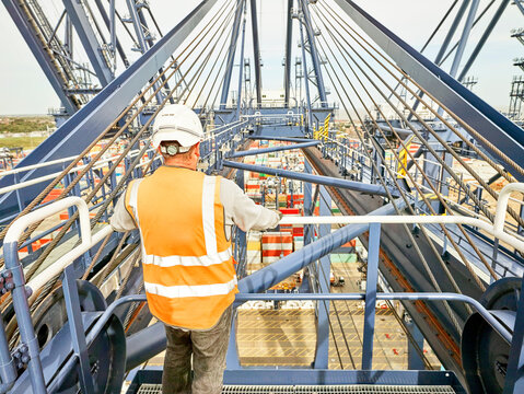 Dock worker by railing of crane