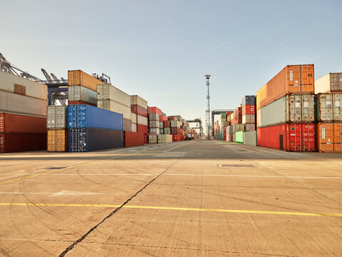 Shipping containers stacked up in docks on concrete, Felixstowe, England.