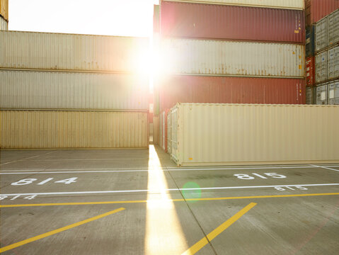 Sunlight shining between shipping containers in docks, Felixstowe, England.
