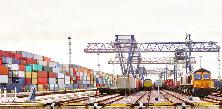 Cargo cranes and shipping containers in dockyard railway, Felixstowe, England