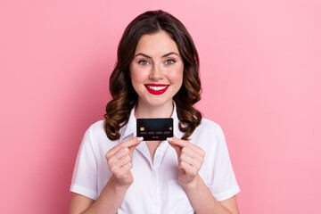 Photo of cheerful positive woman dressed white shirt smiling rising credit card isolated pink color background