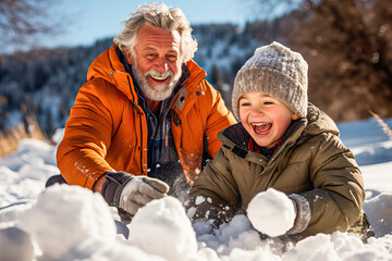 Grandfather and grandson making a snowman in a snowy field - obrazy, fototapety, plakaty