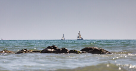 Fototapeta premium Two sailing ships at sea, with coastal cliffs in the foreground