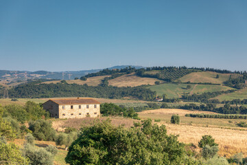 Fototapeta na wymiar Traditional Tuscan landscape with a stone building in the foreground