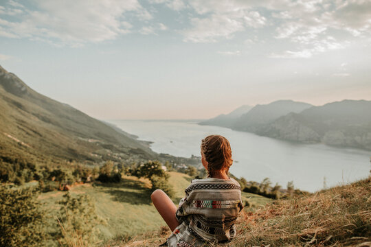 Girl sitting on a hill at Lake Garda in Italy