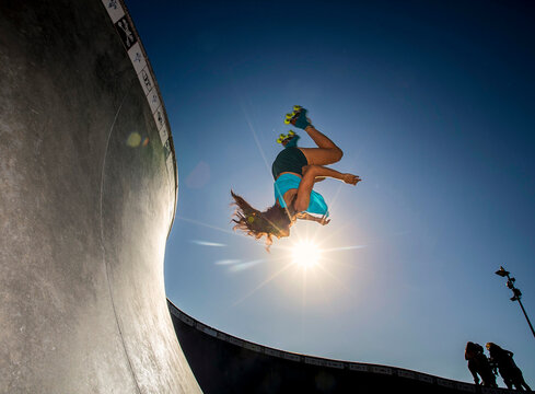 Woman roller skating in bowl at skatepark
