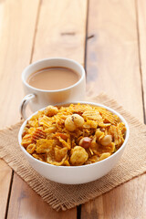 Close-Up of crunchy Indian mixture snacks with hot tea or Coffee. Studio shoot at a declined angle. 