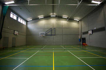 Sports gymnasium  with basketball hoop court and Florescent lighting  - obrazy, fototapety, plakaty