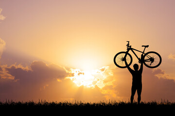 Silhouette of cyclist exercising in the meadow in the evening, fitness health care concept