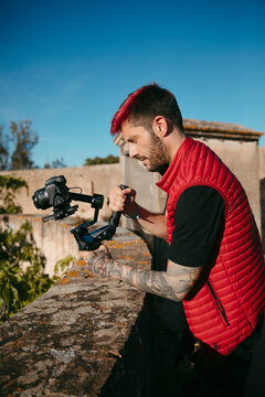 portrait of a tattooed filmmaker with red hair holding a yimbal