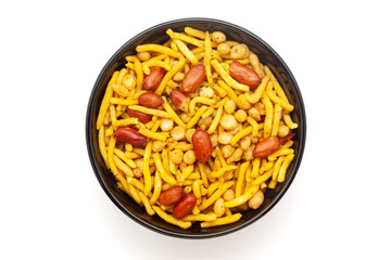 Close-up of South Mix Indian namkeen (snacks) on a ceramic black bowl. Isolated on white background. Top view.