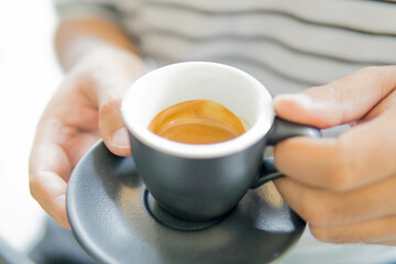man drinking hot coffee in a coffee shop