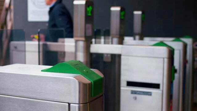 Passengers are going through a tourniquet to the platform. Cinematic video of entrance to the railway station through the tourniquet. Contactless payment by card in the metro saves passengers time
