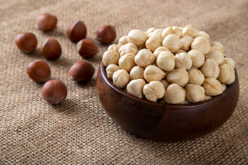 View of a bowl full of peeled hazelnut on burlap sack
