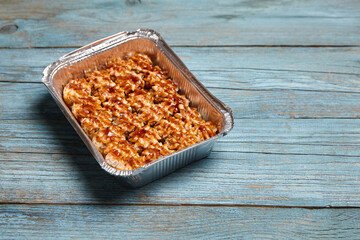 Baked sushi rolls in a baking dish on blue wooden background with copy space. Hot sushi rolls with different kind of fish and fillings. Sushi rolls, a symphony of flavors