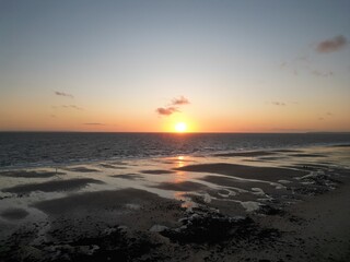 Naklejka premium Coucher de soleil sur une plage à marée descendante