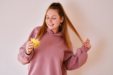 A young woman blows out a candle on a birthday sweet cake. Birthday wishes. Holidays and birthday concept