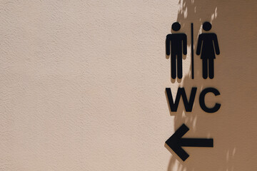 Black male and female public restroom sign with right direction on the wall with shadows.Toilets...