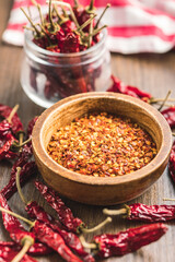 Crushed and whole chili peppers in bowl.