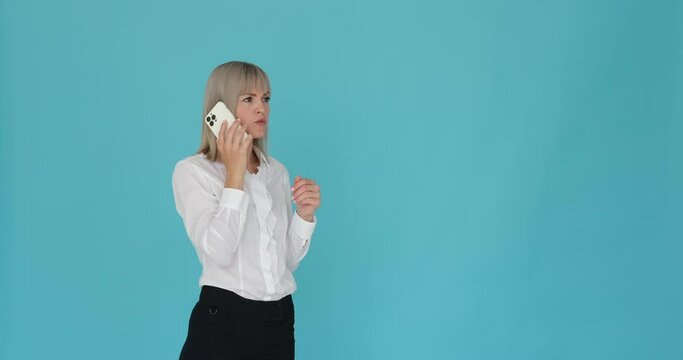 Confident and cheerful Caucasian woman engaged in a phone conversation on a serene blue background. Her beaming smile and assured demeanor convey her self-assurance.