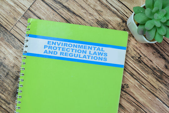 Concept of Environmental Protection Laws and Regulations write on book isolated on Wooden Table.