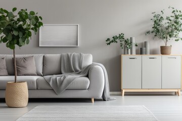 This is a genuine photograph of a gray and minimalist living room with a Scandinavian cabinet featuring a drawer and a green plant on top. Additionally, there is a comfortable couch adorned with