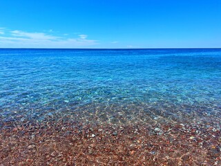 Obraz premium Blue sea and beautiful pebbly beach.