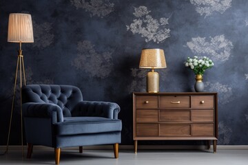 An artistically composed and glamorous living room interior design featuring a wooden commode, a stylish lamp, and elegant personal accessories. The room is adorned with a dark blue wallpaper, making