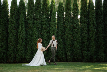 wedding walk of the bride and groom in a coniferous