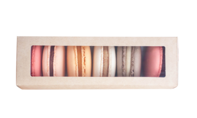 Assorted colorful macarons on cardboard box isolated on white background