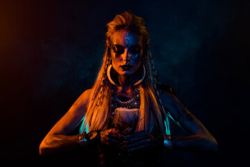 Photo of mysterious viking conjurer girl prepare immortality elixir orange lights isolated on black...