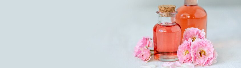 Composition with pure natural organic rose essential oil in glass bottle, luxury perfumery...