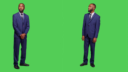 Male entrepreneur having amazed and surprised reaction, feeling stylish in business office suit over full body greenscreen. Corporate employee in awe seeing something in studio.