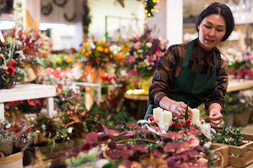 Asian woman selling new year decors at flower shop. Christmas decoration shopping