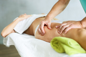 Close-up picture of deep anti-cellulite massage session for female patient.