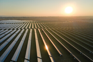 Aerial view of big sustainable electric power plant with many rows of solar photovoltaic panels for...