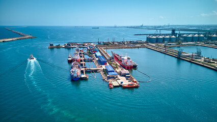 Aerial top view of oil tanker ships at the port, Oil terminal is industrial facility for storage of oil and petrochemical products ready for transport to further storage facilities.