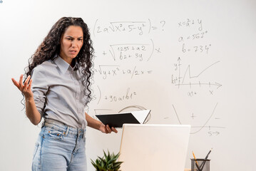 Stressed From Work. Uptight Young Mixed Race Female Teacher in Screaming Out Loud, Gesturing and Looking on Laptop, Having Video Lesson with Students, Tutoring Math Lesson Online, Standing at Desk