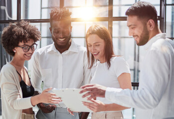 Employees working at computer together, discussing content