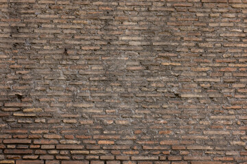 A dark brown old brick European wall in Rome Italy