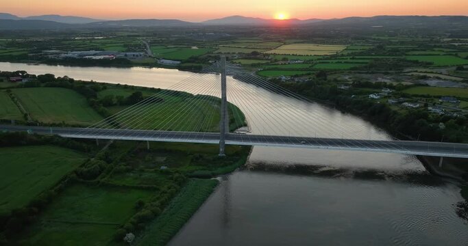 The massive cable-stayed bridge over the Suir River against the sunset 4k
