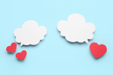 Paper hearts with blank speech bubbles on blue background
